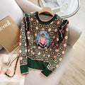 Green printed knit sweater on hanger showing loose fit and graphic pattern detail