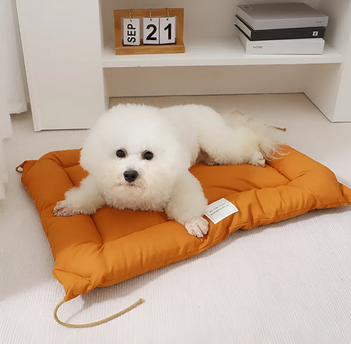 Beige pet cage cushion secured inside a metal dog crate, showing tie straps.
