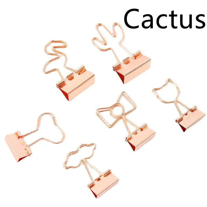 Small gold-plated metal office clip with a long tail, shown in a choice of flamingo, love, clouds, cat, and cactus shapes.