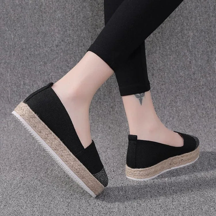 Women's plus size black canvas slip-on flat shoes with round toe, shown from the side.