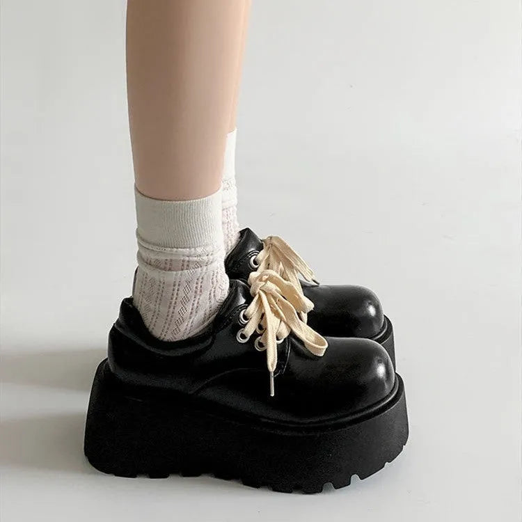 Matte black women's lace-up shoes with a chunky English muffin heel and thick rubber sole.