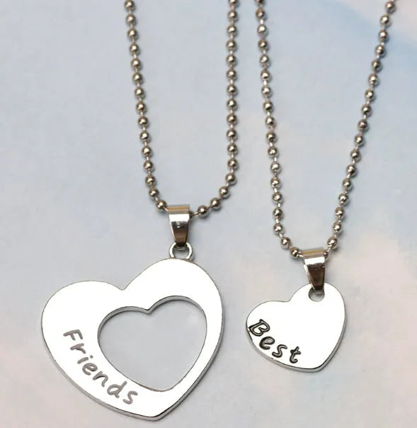 Two silver alloy heart-shaped puzzle necklaces on cross chains, matching set