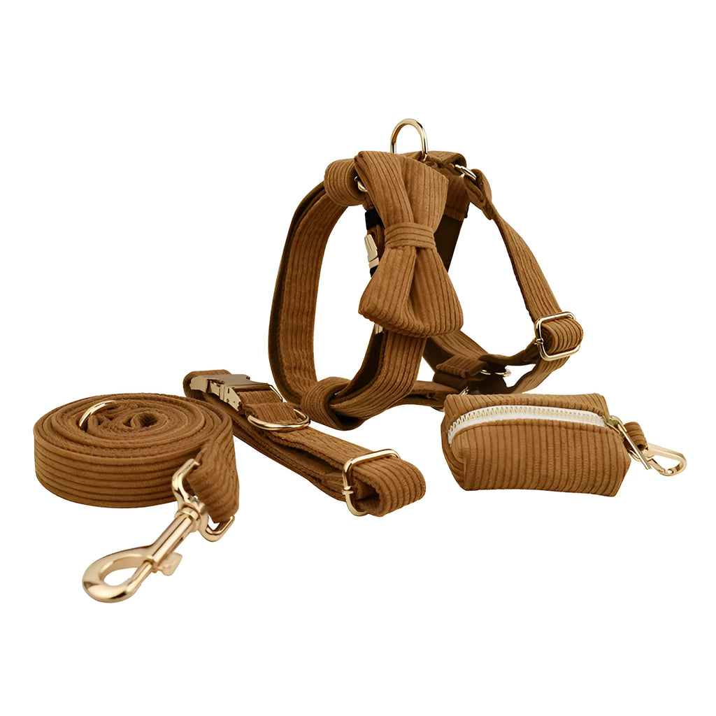 Caramel corduroy pet collar set with ring, rope, bow, vest, and poop bag on a light background