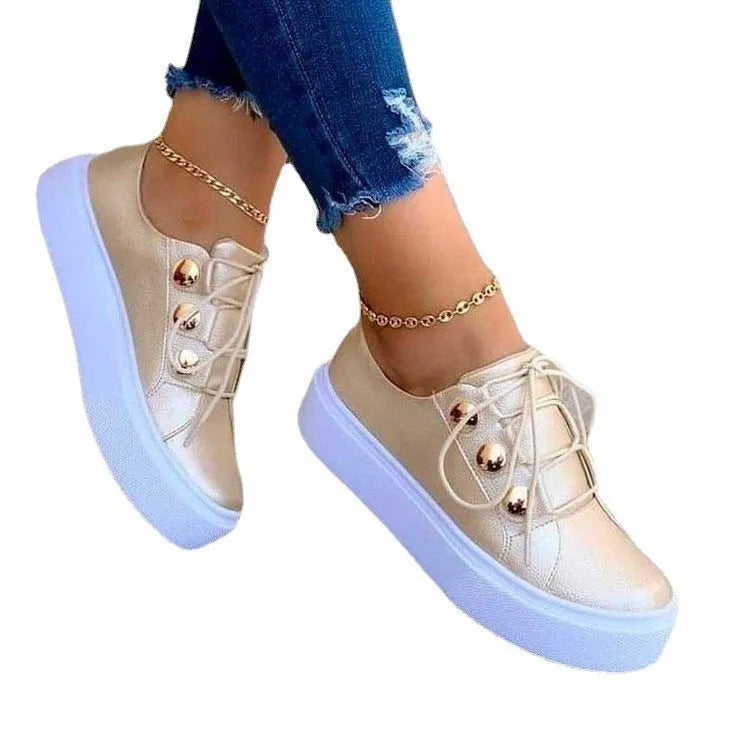Women's white lace-up flats sneakers with round toe and silver rivet details on the low upper.