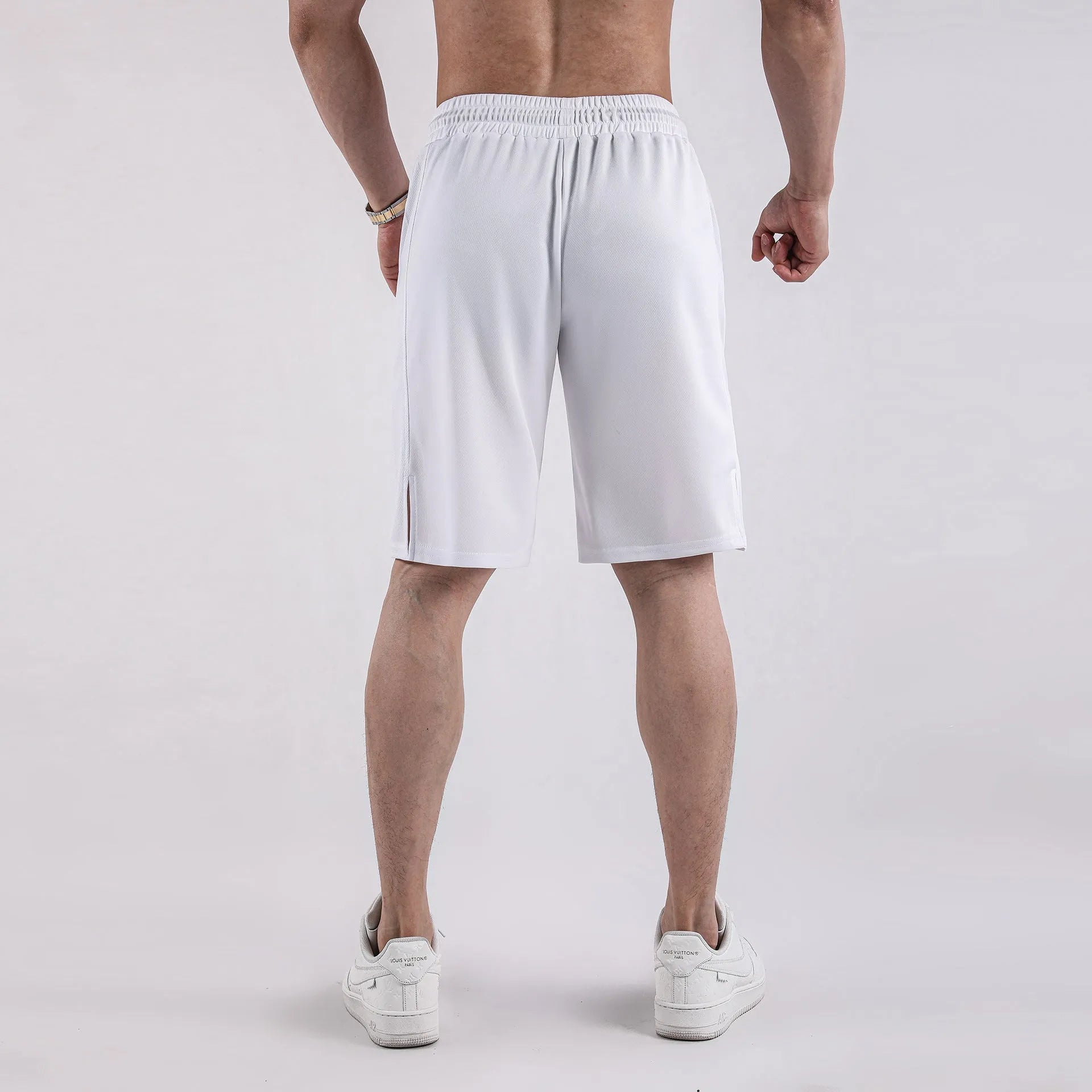 A man wearing loose-fitting black quick-dry mesh fitness shorts with an elastic waist.