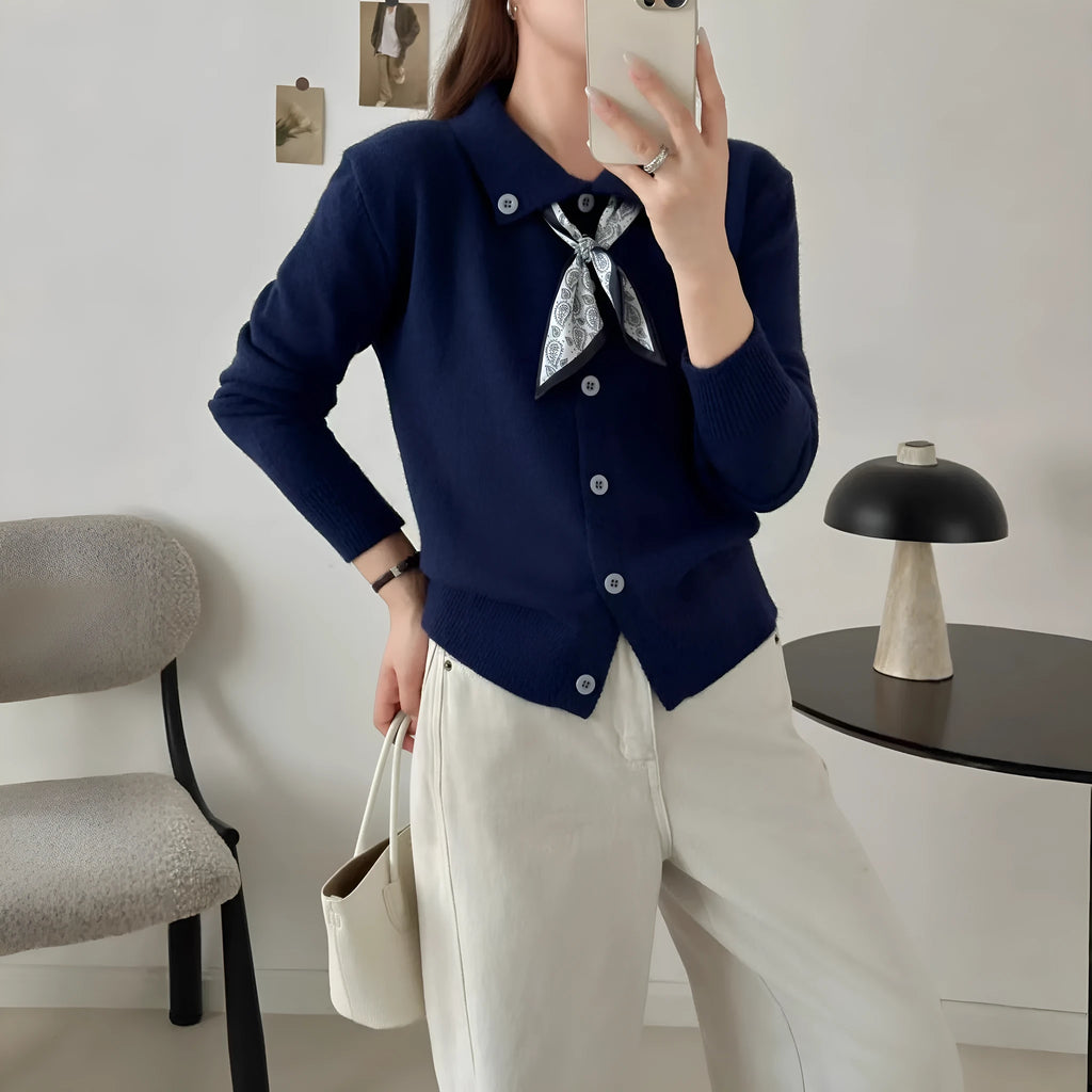 Milky white acrylic fibre cardigan sweater with a lapel scarf and long sleeves laid flat