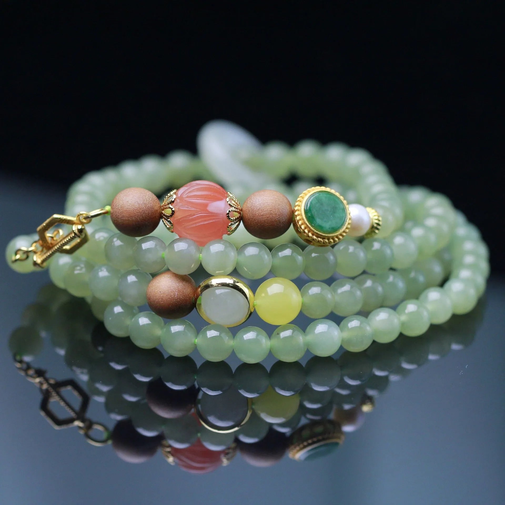 Hetian jade necklace with lotus beads, zodiac charm, and matching bracelet on white background