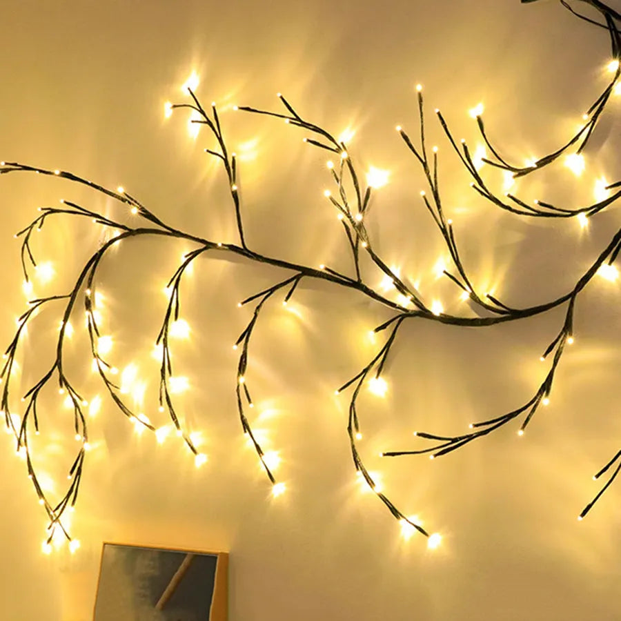 Flexible LED vine garland with warm white lights bent into decorative shape on wall