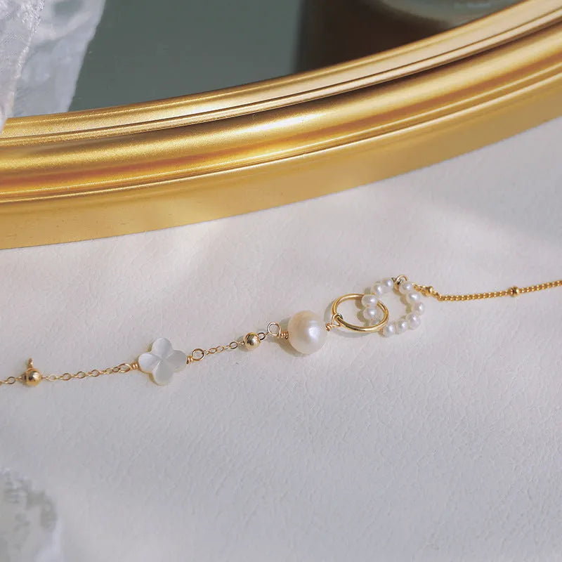Women's adjustable natural pearl bracelet with gold-plated clasp on white background