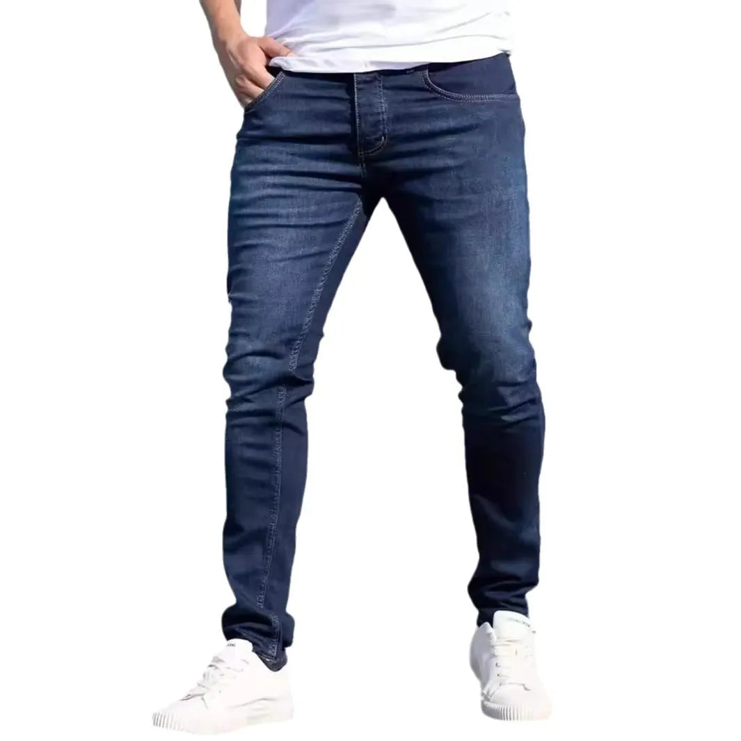 A man wearing dark blue slim fit casual jeans with an elastic waistband.