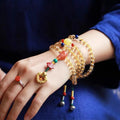 Yellow natural citrine bracelet with 1mm beads and filament accessory details on a wrist.