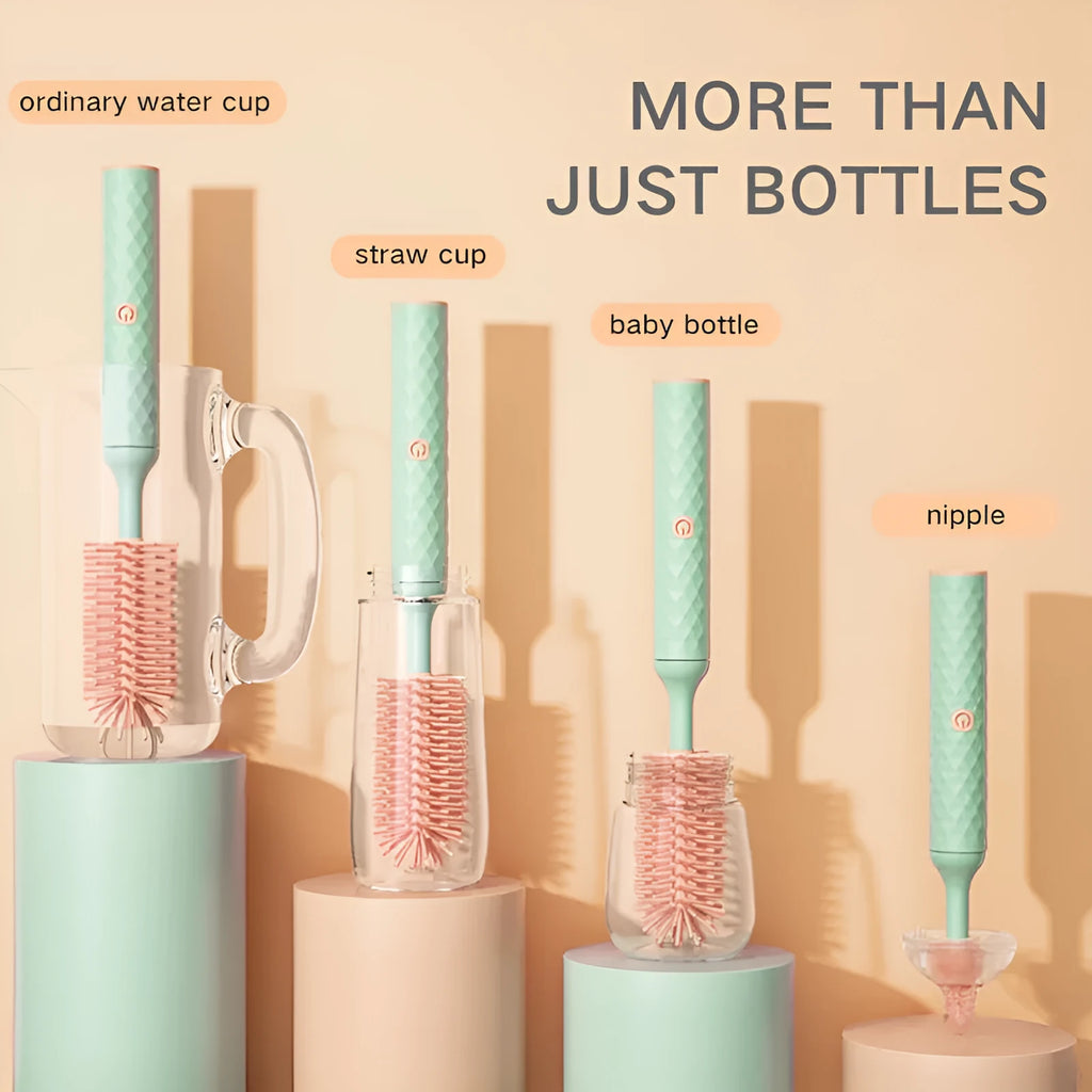 Pink and green electric baby bottle cleaning brush with rotating silicone head on a table