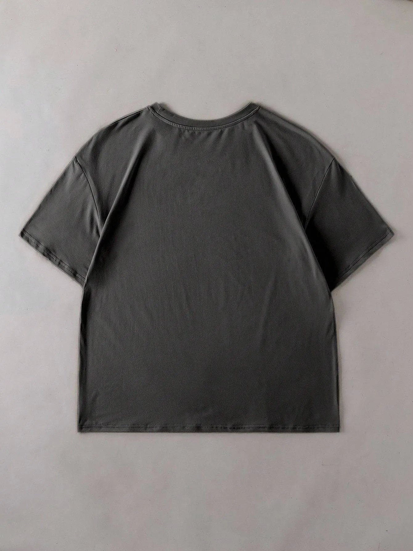 Loose short-sleeve cotton T-shirt on a hanger, showing round neckline, available in black, green, grey, and orange.