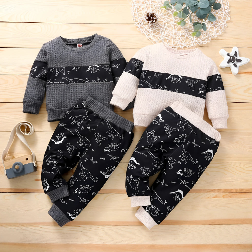 Cotton children's pants suit with dinosaur cartoon pattern in beige, pullover top and trousers set on child model