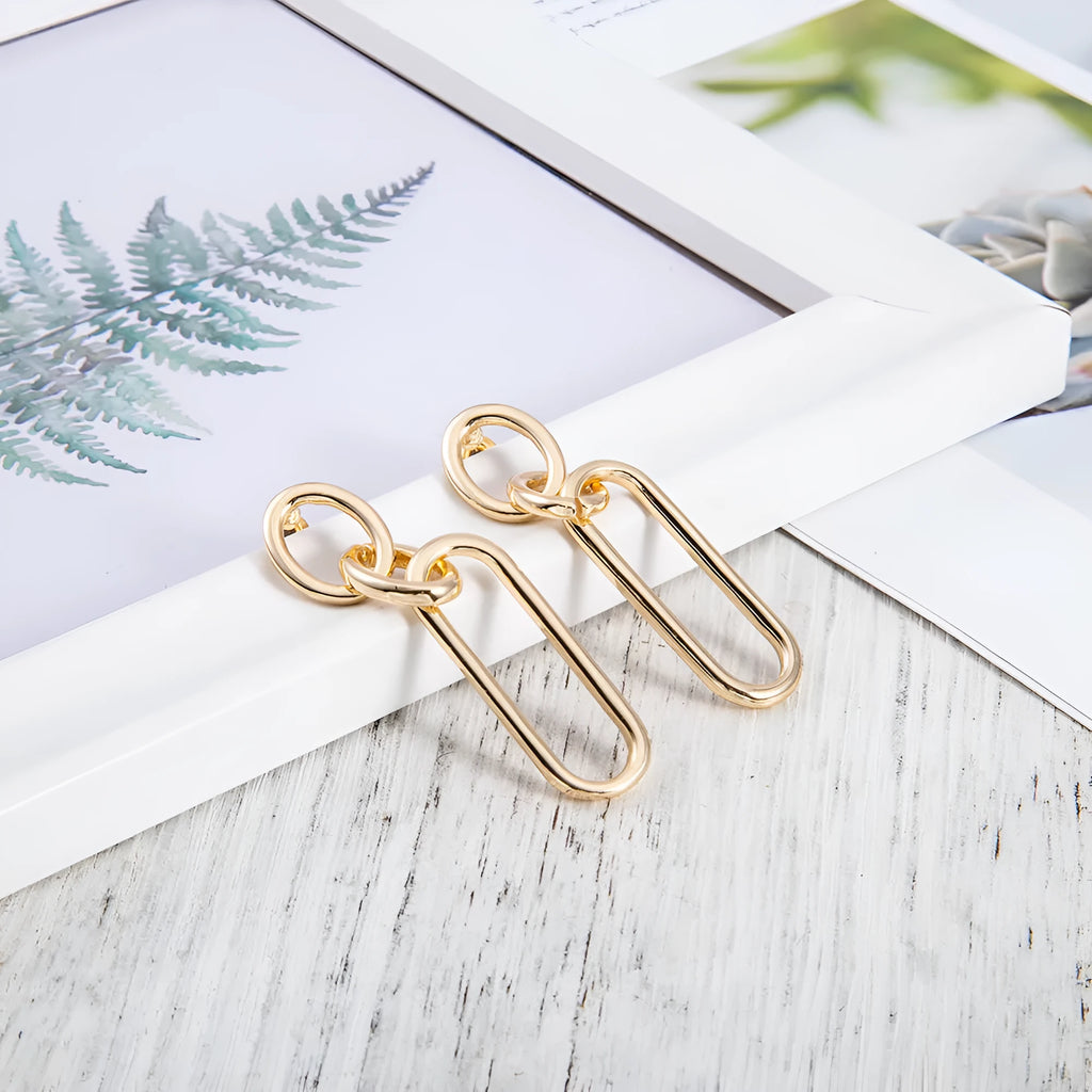 Geometric sterling silver colour hoop earrings with a ring and line design on a white background.