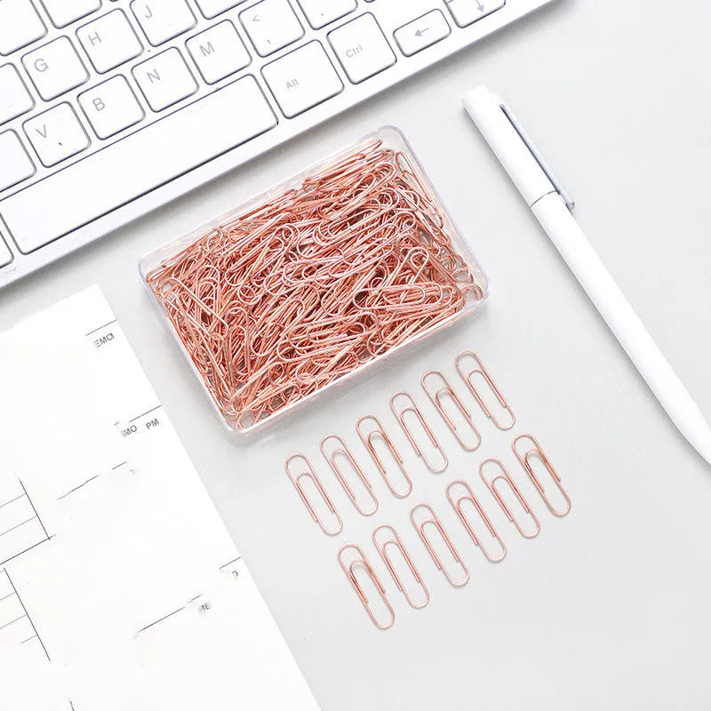 Rose gold coloured metal heart-shaped paper clips, size 28mm, in a box of 100 pieces.