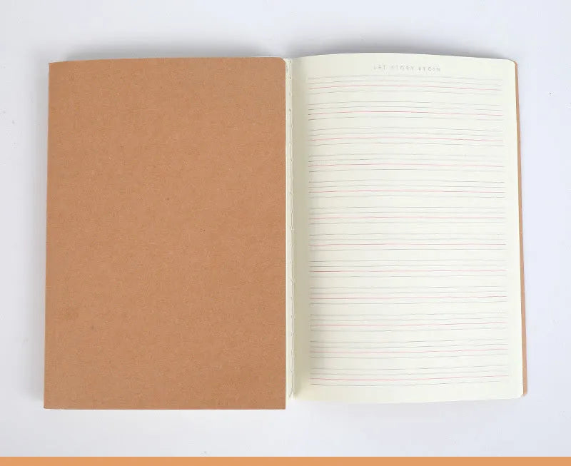 Softcover thread-bound notebook open on a table, showing flat-lay binding and lined paper.