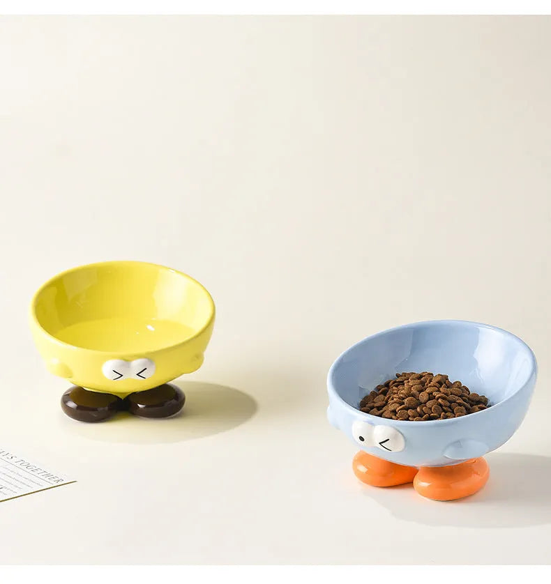 Tall blue ceramic slanted pet bowl with cute expression, designed for cervical spine support.
