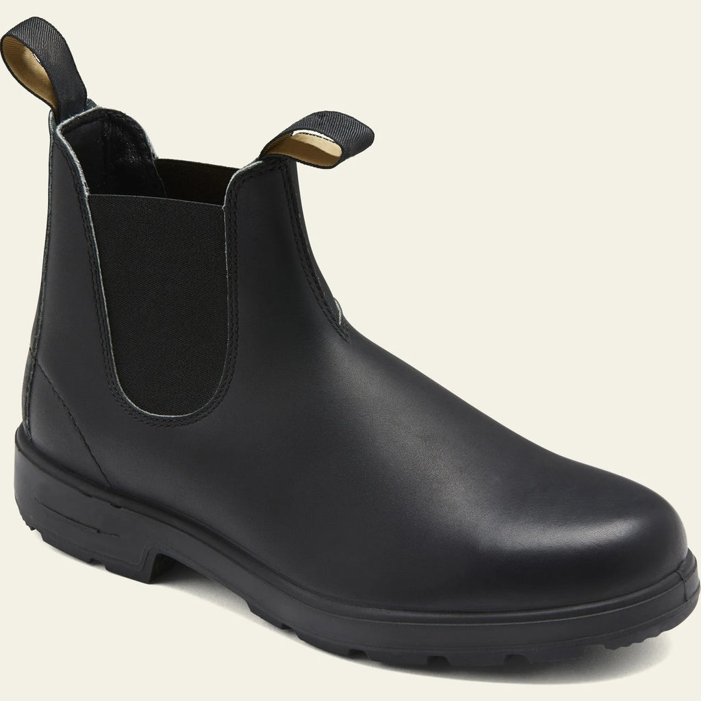 Vintage frosted brown leather Chelsea boots with round toe and car suture detailing on a wooden floor.