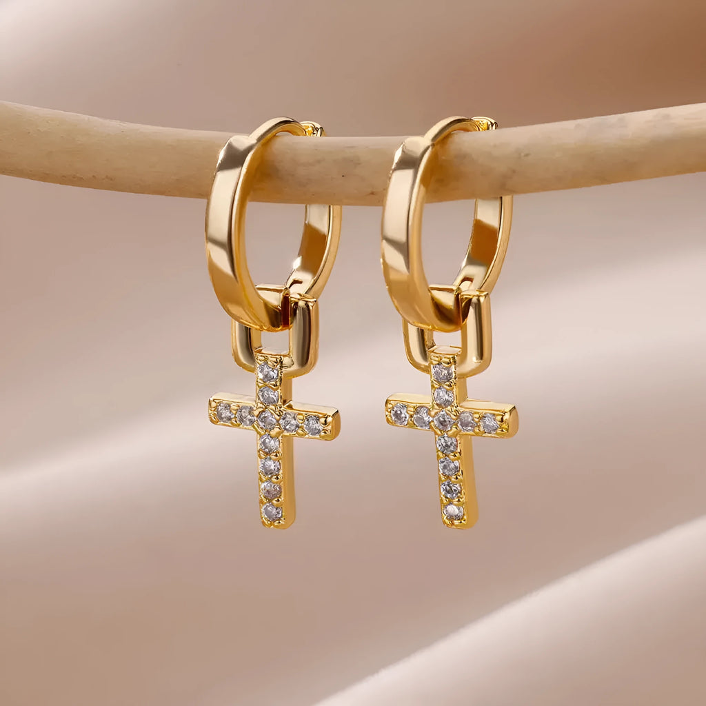 Cross stud earrings with 18K gold plating and clear zircon stone on a white background