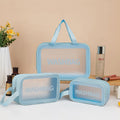 Large PVC transparent cosmetic bag three-piece set in various colours including beige, black, blue, pink, and white, empty and open on a flat surface