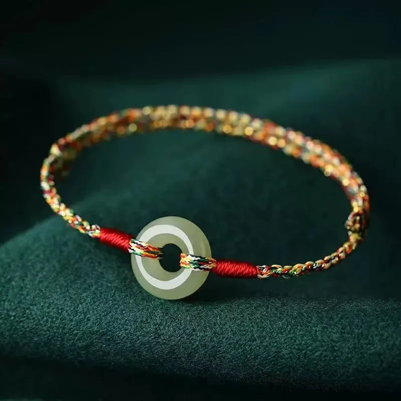Handmade woven rope bracelet with silver peace buckle clasp on colourful braided cord