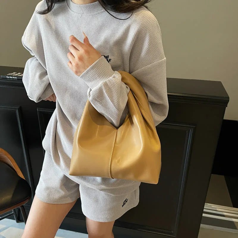 Casual dumpling-shaped women's PU shoulder bag in multiple colours showing internal phone and file pockets.