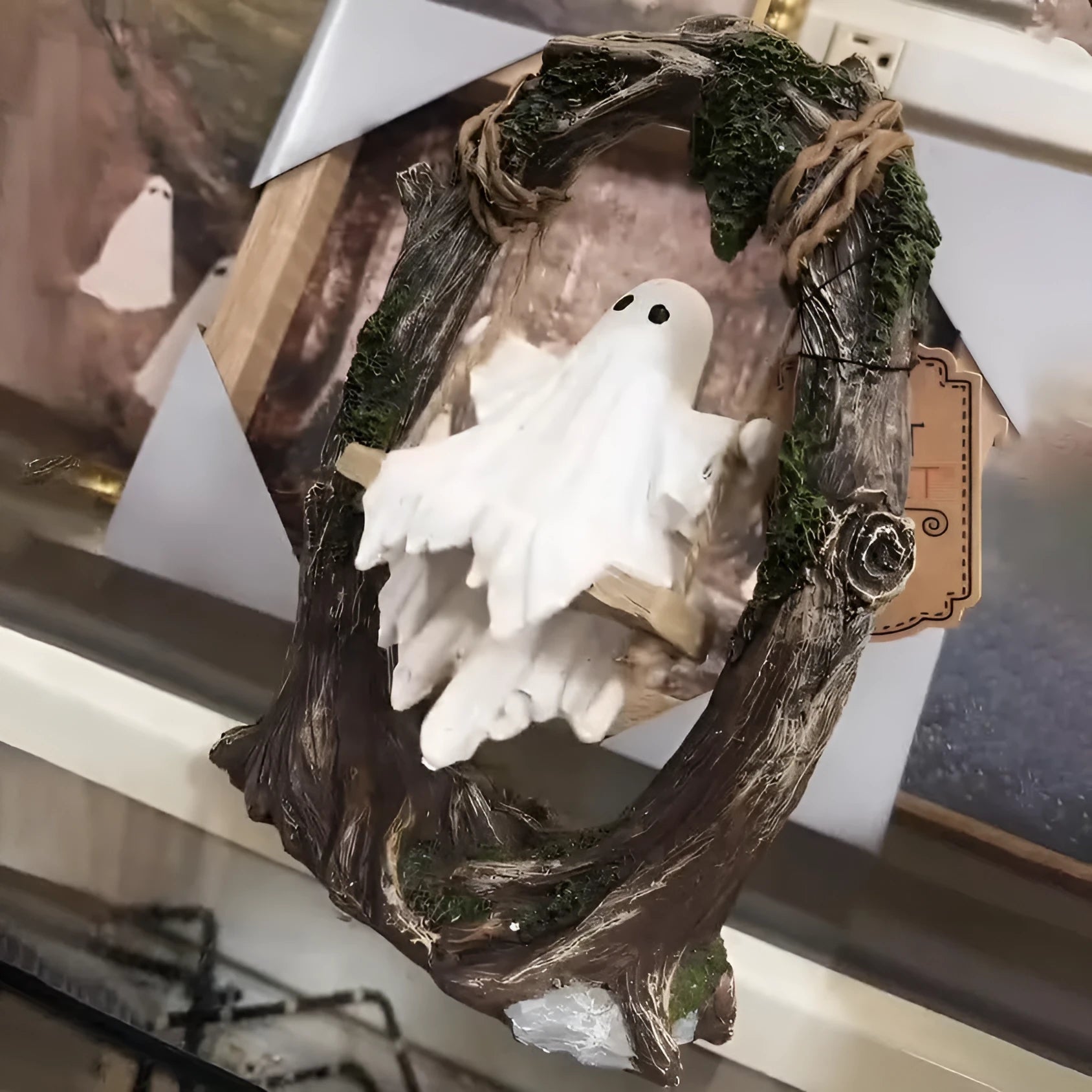 Modern Halloween decoration featuring a stylised white resin ghost on a black swing frame, with two design options shown.