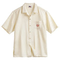 Light apricot men's Cuban collar shirt with bamboo and floral plant pattern.