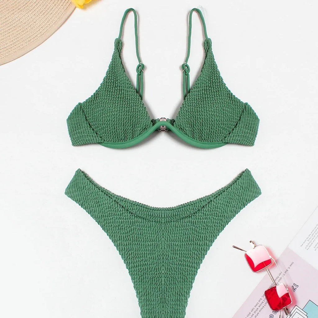 Women's solid green bikini suit with ruffle detailing and split-front design on mannequin