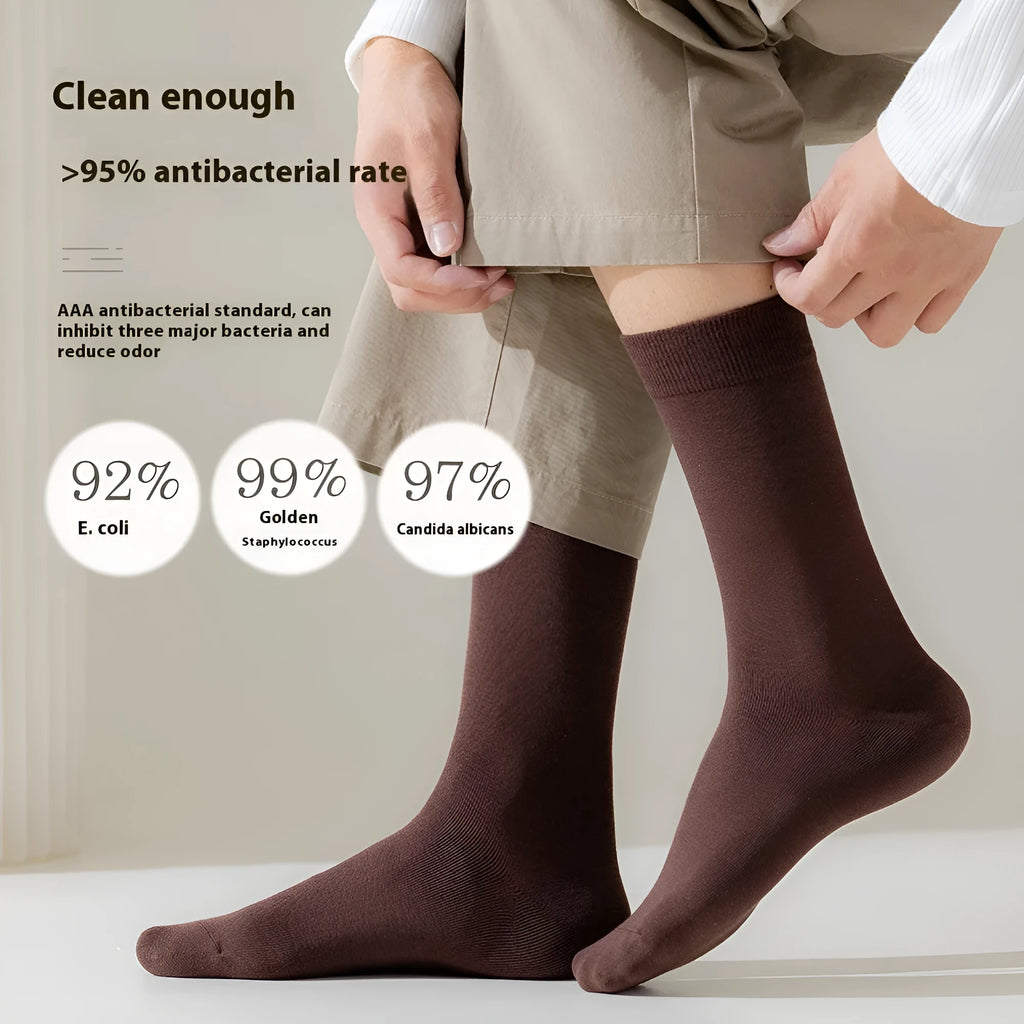 Five pairs of men's solid colour mid-calf socks made from combed cotton, shown in assorted shades.