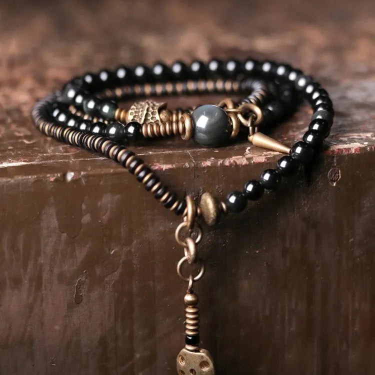 Black geometric patterned beaded bracelet with multi-layered natural materials design