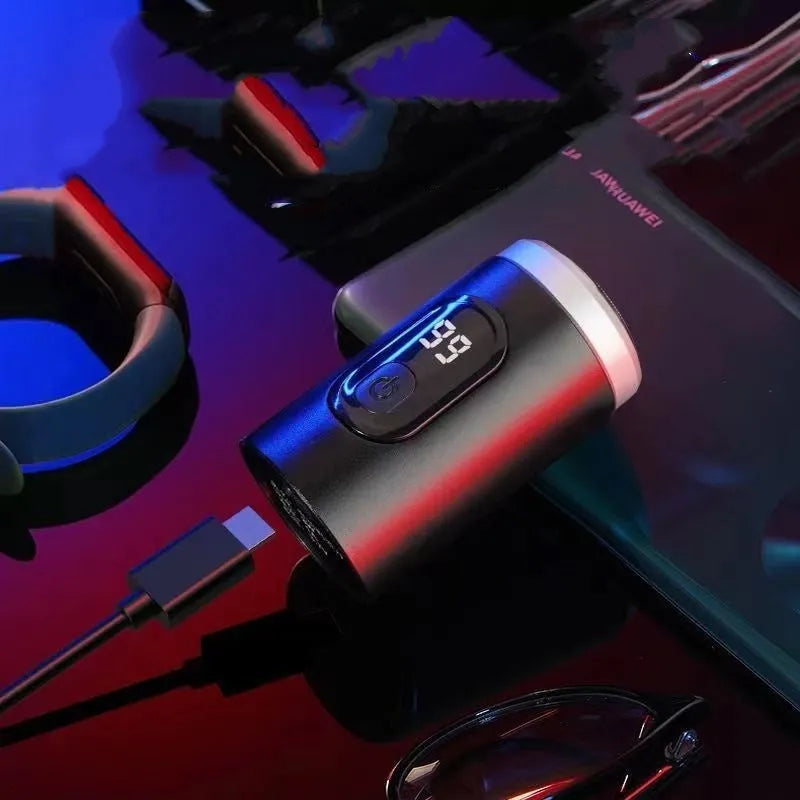 Black mini portable electric shaver with USB charging cable and cleaning brush.