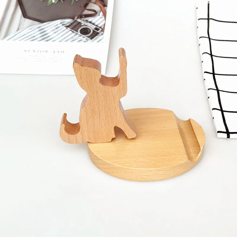 Beech wood and resin lazy bracket mobile phone holder in an animal design style on a desk.