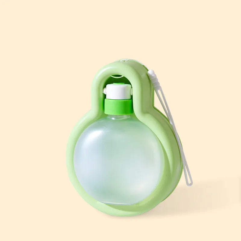 Green portable pet travel cup with pull-out drinking bowl for dogs on outdoor adventures