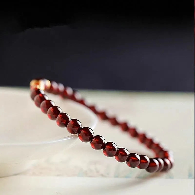 Close-up of a wine red glass bead bracelet showing micro beads and coloured glaze finish.