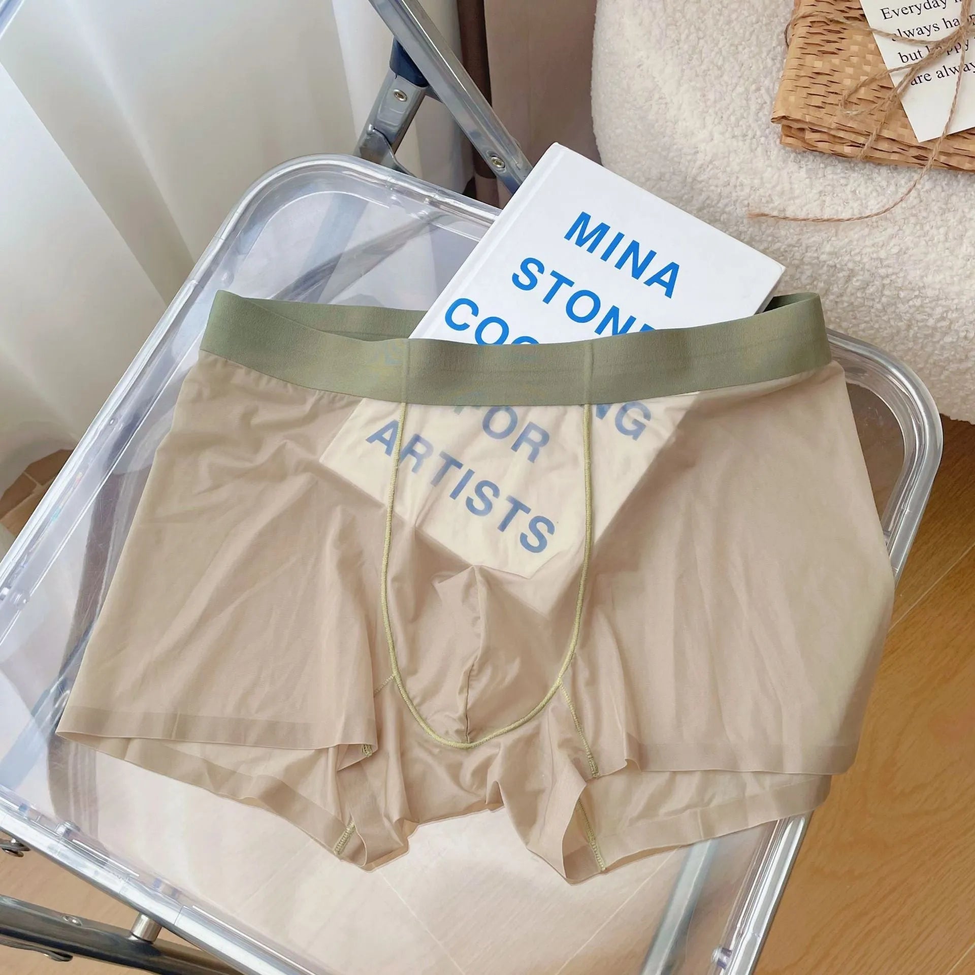 Men's thin grey seamless nylon boxer shorts laid flat, showing mid-waist and body-shaping design.