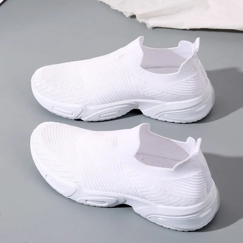 A pair of low-top slip-on sock shoes with a mesh upper and PVC sole on a plain background.