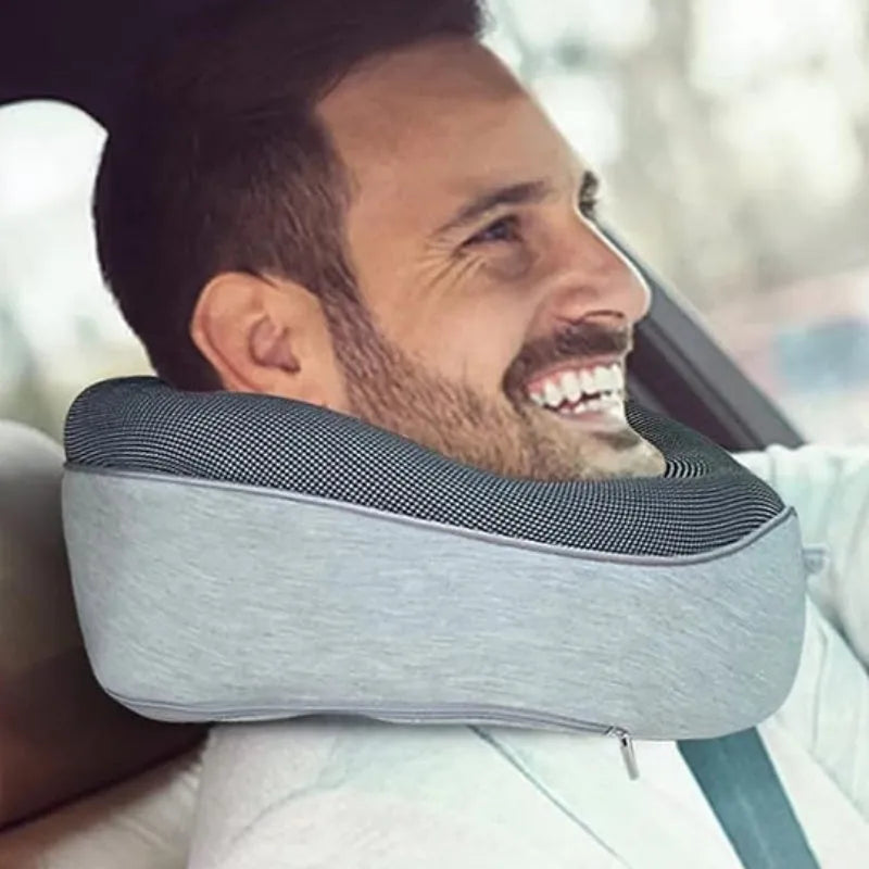 U-shaped memory foam travel neck pillow rolled up next to its carry bag, showing navy blue and grey colour options.