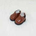 A pair of 17cm scale PU doll shoes in a selected colour and style, such as black leather shoes or brown boots.