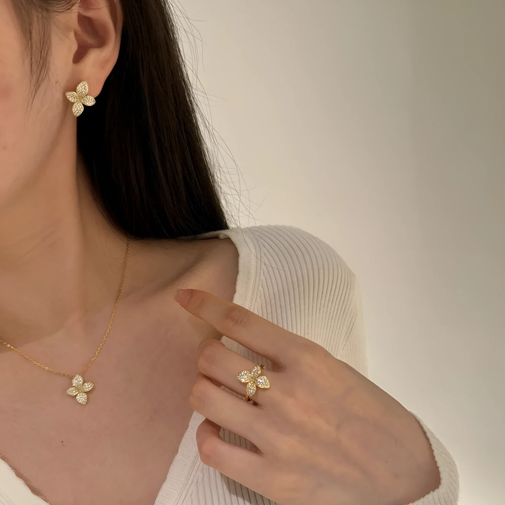925 silver flower design open ring, necklace, and earring suite with white zircon inlay on a white background