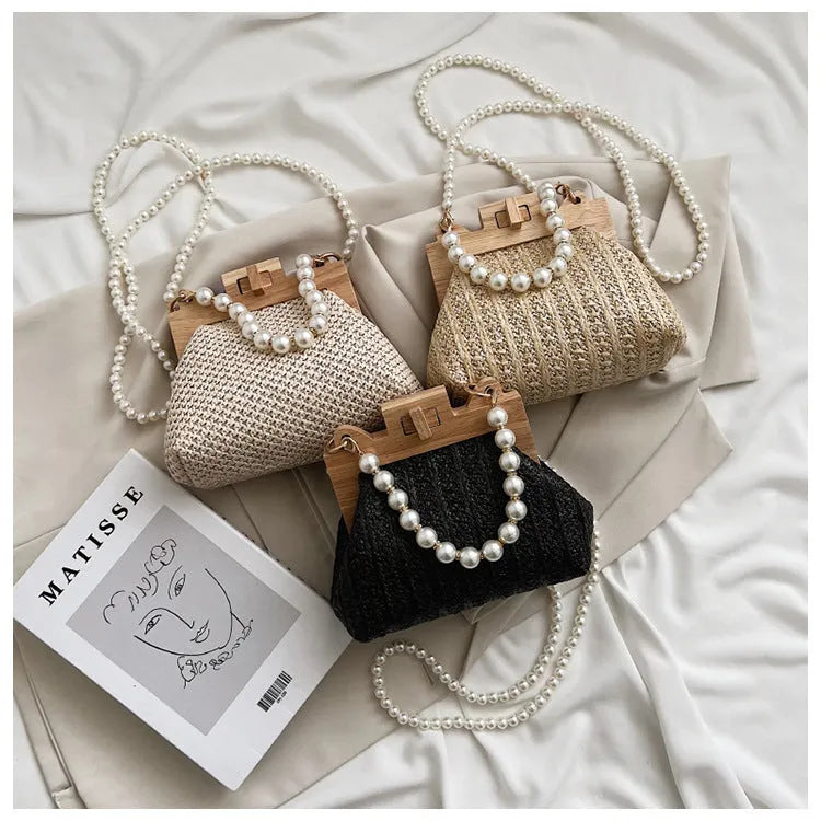 Women's straw woven shoulder bag with pearl chain strap showing interior organisation pockets