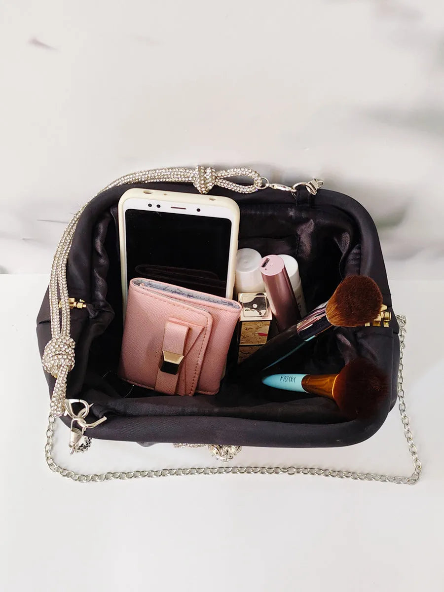 Women's black polyester messenger bag with chain detail, diamond patterns, and document organiser compartment