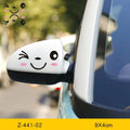 Pair of reflective cartoon eye car stickers on a vehicle rearview mirror.