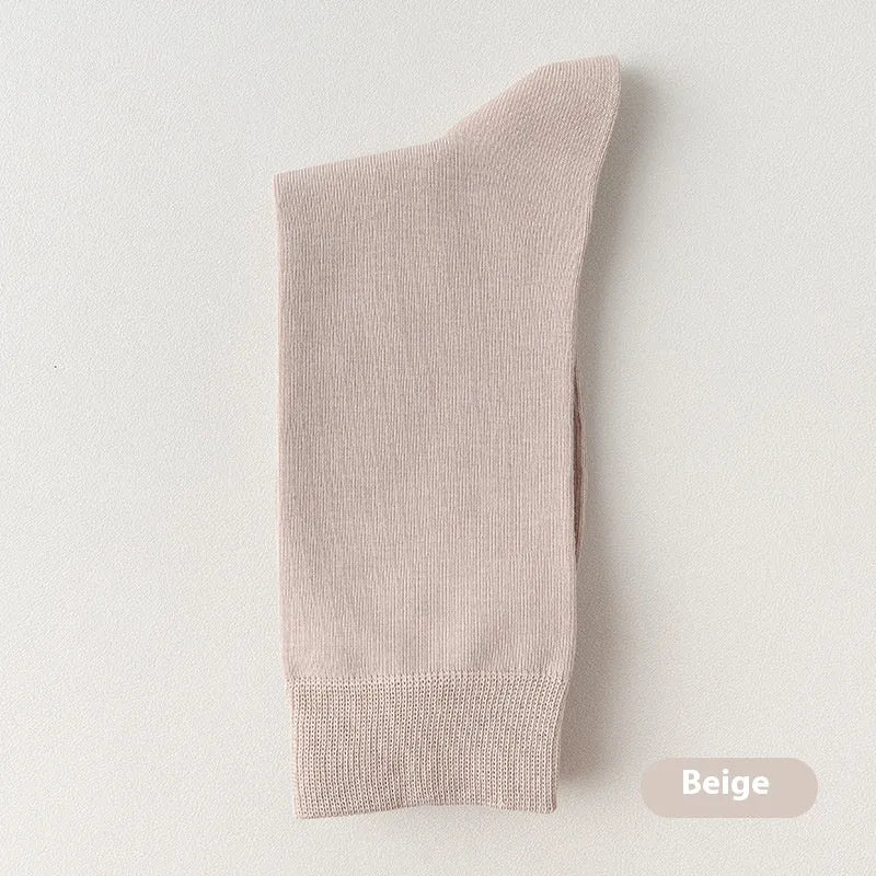 Five pairs of men's solid colour mid-calf socks made from combed cotton, shown in assorted shades.