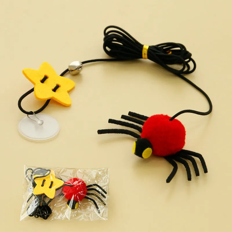 Red and yellow feather cat toy hanging from door on elastic rope with bell spider element for indoor feline play