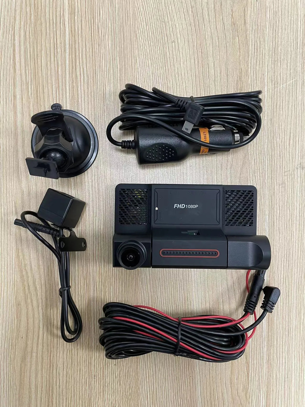 Black car dashcam with 4-inch touchscreen display showing dual camera view, mounted on a car windscreen.