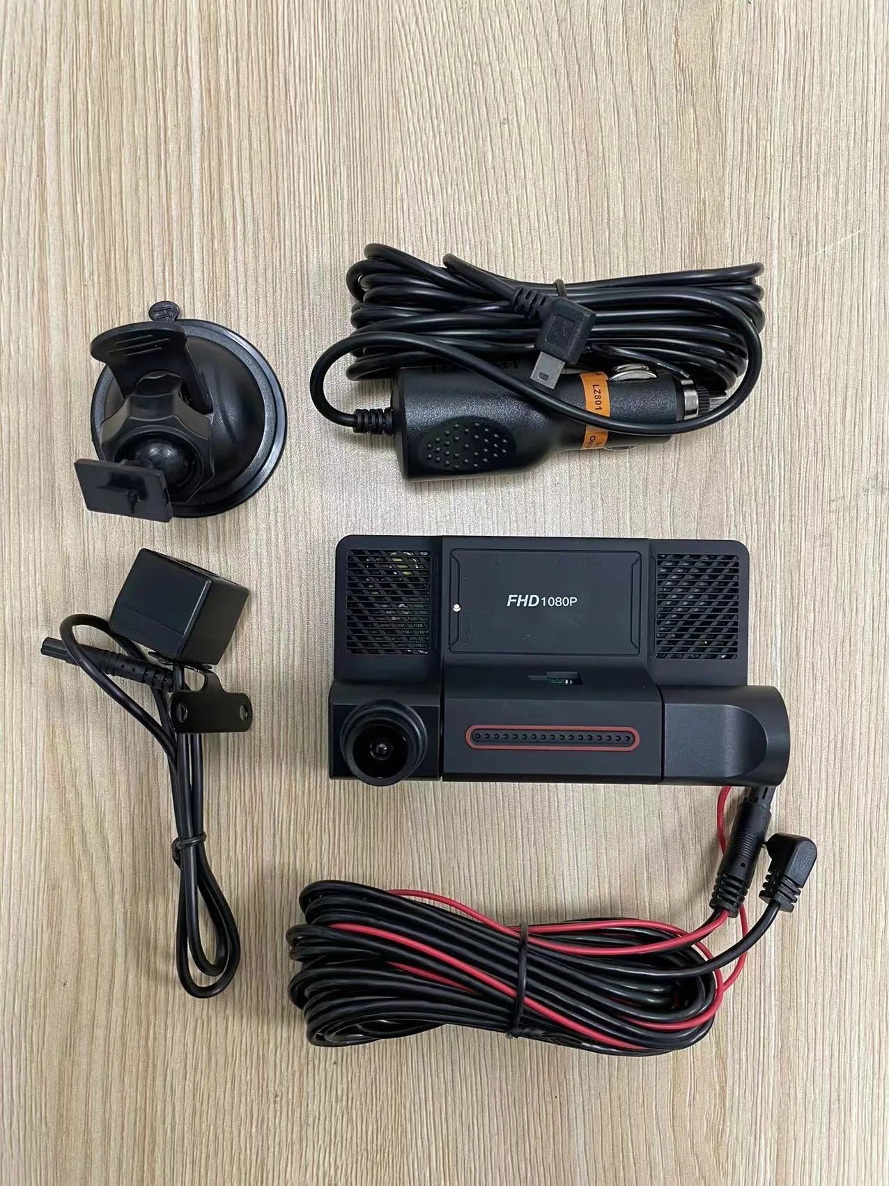 Black car dashcam with 4-inch touchscreen display showing dual camera view, mounted on a car windscreen.