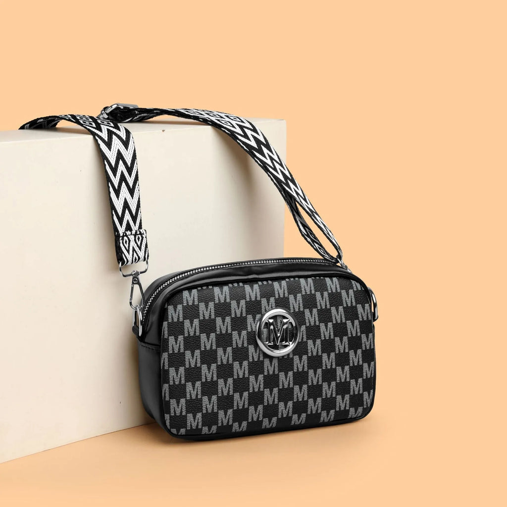 Black wide-strap crossbody bag made of PU leather, showing the three-dimensional outer pocket and adjustable shoulder strap.