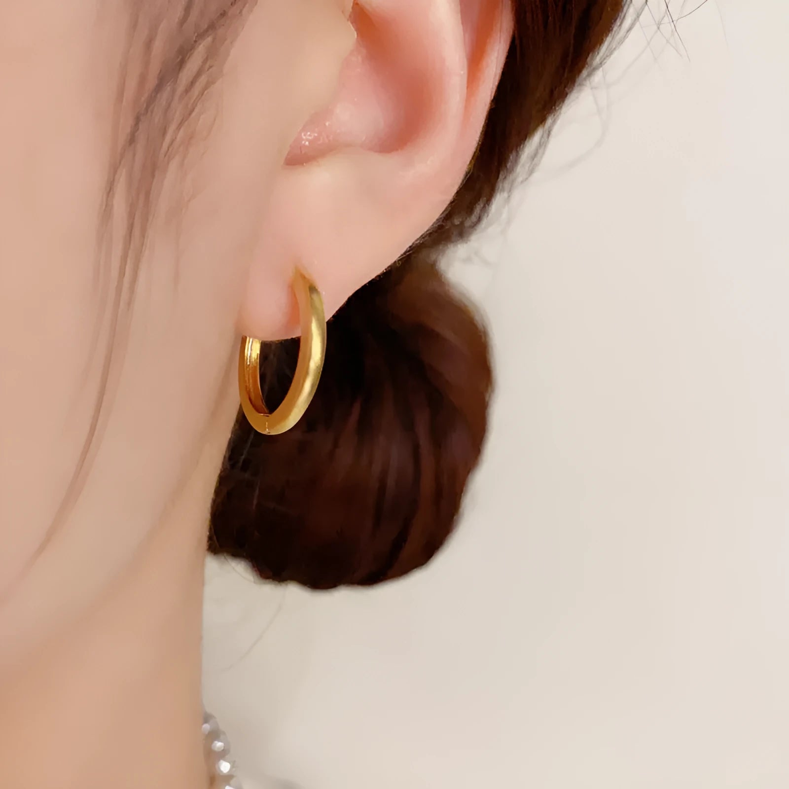 Women's geometric round eyelet ear clips in gold and silver colours, showing front view.